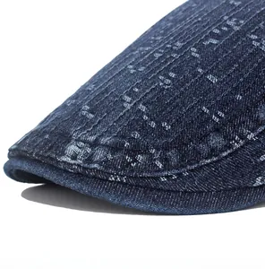Close-up of textured washed cotton denim newsboy cap with white snow-point weave detail