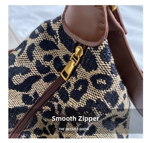 Close-up of leopard print fabric bag showing smooth golden metal zipper and brown leather trim