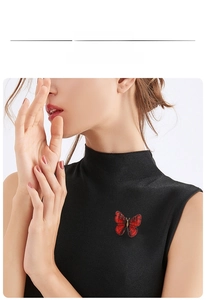 Vue détaillée d'une élégante broche papillon brodée sur un haut noir sans manches