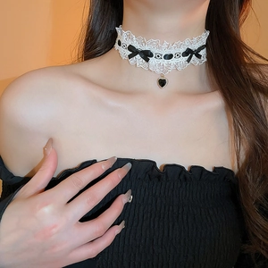 Elegant white lace choker necklace with black bow and heart pendant on model