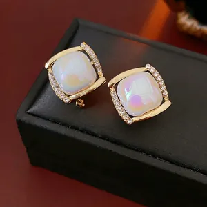 Square gold stud earrings with iridescent blue-purple stones and zircon accents