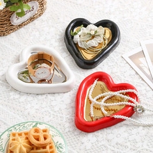 Detailed close-up of heart-shaped ceramic jewelry trays with gold mirror finish and matte texture