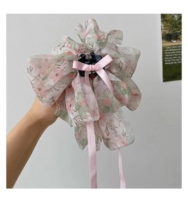 Close-up of floral chiffon shark hair claw with a pink satin bow and fabric ribbon