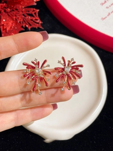 Close-up of red enamel fireworks earring with heart-shaped cubic zirconia stone
