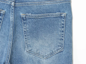 Detail view of back pocket stitching and fabric texture on blue denim wide leg pants