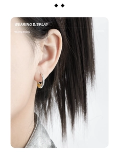 Detailed view of bicolor C-shaped geometric hoop earring worn by a female model