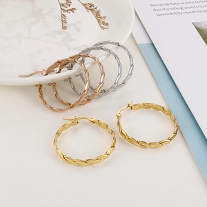 Fashion twisted rope hoop earrings in gold, silver, and rose gold on white plate