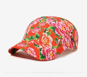 Side view of red cotton flat cap featuring traditional pink peony floral patterns