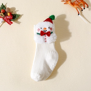 Détail de chaussettes bébé en tricot blanc avec bonshommes de neige et nœuds rouges