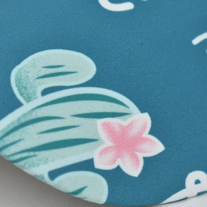 Close-up of the cyan blue fabric texture with cactus print and white typography detail