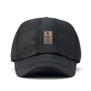 Dettaglio del berretto da baseball camo nero con patch logo in pelle sportiva