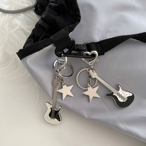 Detail eines silbernen E-Gitarren-Schlüsselanhängers mit Sternanhängern am Rucksack