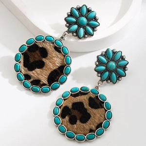 Detail of bohemian drop earrings with turquoise stones and leopard print circular pendants