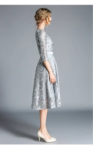 Detailed close-up of light grey lace floral texture and slim waist design on the dress