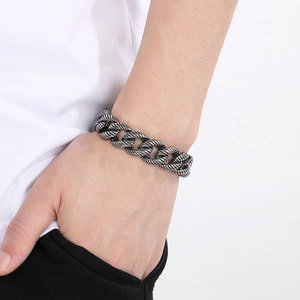Detailed view of vintage silver textured chain bracelet with engraved clasp on male wrist