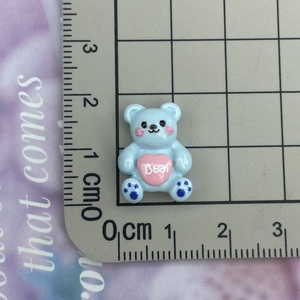 Detailed view of mini light blue resin bear accessory with pink heart and Bear engraving