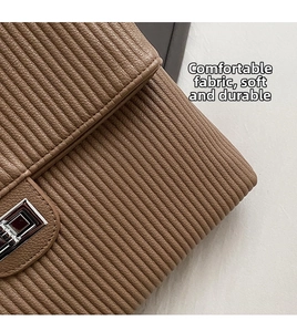 Close-up of tan quilted leather texture and silver rectangular metal flip lock on bag