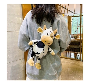 Rear view of a person wearing a cute black and white plush cow crossbody bag for kids