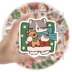Handheld 6.5cm Christmas sticker featuring a cat with reindeer on a green background
