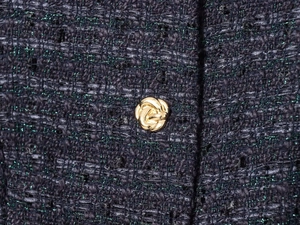 Gros plan détaillé du tissu en tweed bleu foncé avec bouton noeud doré et fils brillants