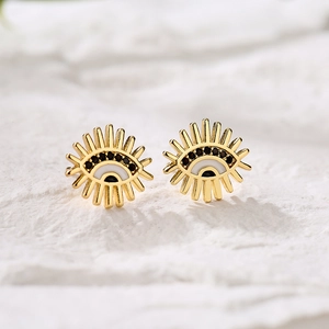 Golden sun-shaped evil eye stud earrings with white enamel and black bead center