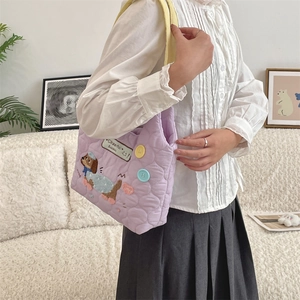 Detalle del bolso tote acolchado morado con bordado de cachorro y botones de colores