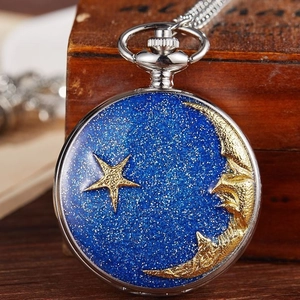 Vintage silver pocket watch with blue starry sky dial and golden moon on wooden surface