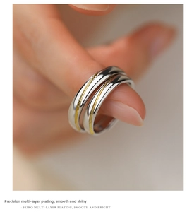 Close-up of interlocking s925 silver rings with gold sand finish on a model's hand