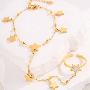 Elegant gold-tone star pendant hand chain ring bracelet on a white textured background