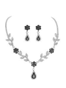 Macro shot of silver flower necklace and drop earrings with black stones and rhinestones