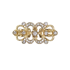 Golden bow-shaped sweater clip with clear rhinestones and elegant metallic finish