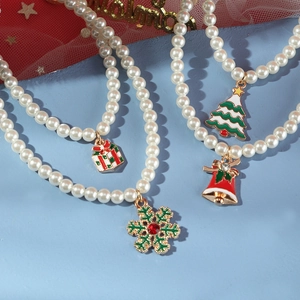 Christmas pearl necklace with colorful enamel charms like tree and bells on blue background