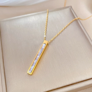 Macro shot of rectangular white shell pendant on a gold titanium steel O-chain