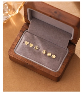 Dettaglio del set di orecchini a lobo in argento S925 placcato oro con cuori e fiori