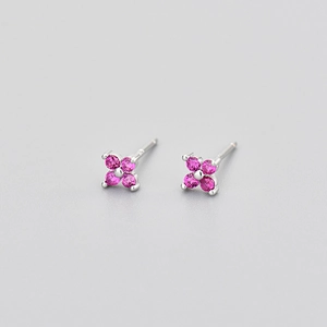 Silver flower stud earrings with four round rose red zircons on a gray background