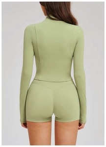 Detail of ergonomic back stitching on light green slim-fit yoga jacket and shorts