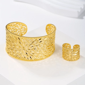 Detailed view of gold hollow floral patterns on adjustable bracelet and matching ring set