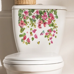 Macro detail of floral toilet sticker with pink flowers and green leaves on white ceramic