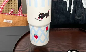 Close-up of white insulated tumbler with cute cat patterns and Good Luck text
