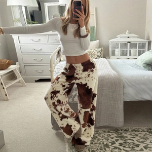 Détail du pantalon en polaire ample avec motif vache et texture pelucheuse douce