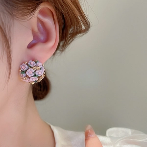 Macro detail of 3D pink floral cluster earrings with sparkling crystals on model