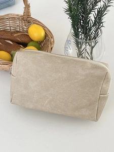 Detail of minimalist beige PU makeup bag showing textured water-resistant fabric and zipper
