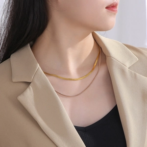 Double-layered gold titanium steel flat snake chain necklace worn by a female model