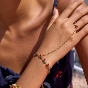Macro view of 18K gold stainless steel hand chain with red and green cherry charms