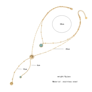 Close-up of golden double-layer stainless steel necklace with tree of life and turquoise