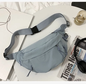 Flat lay of a light blue streetwear fanny pack with headphones and vintage props