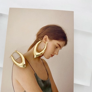 Polished gold hollow U-shaped drop earrings shown with a professional model and product view