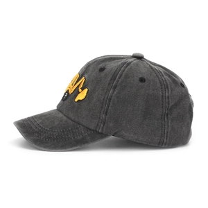 Close-up of yellow excavator embroidery on dark gray washed cotton kids baseball cap