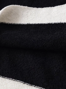 Macro detail of high-quality black and white striped knit fabric with soft texture and stitching