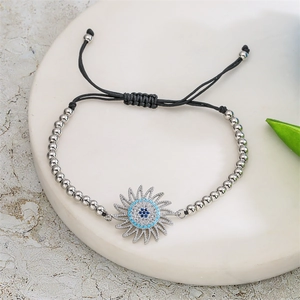 Détail du bracelet bohème en perles argentées avec charme œil de soleil et cordon noir